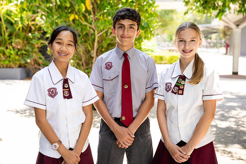 Three students standing and facing the camera.
