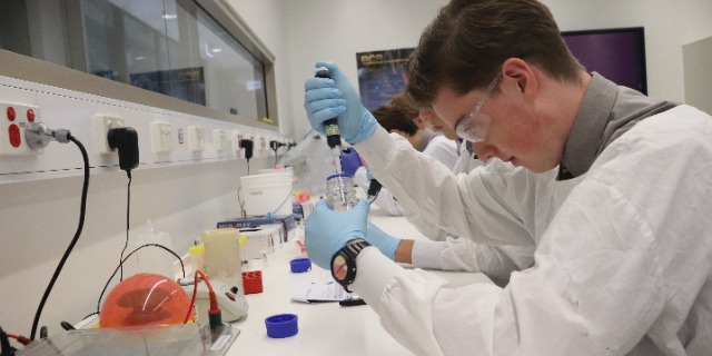 Students in a lab using a syringe.