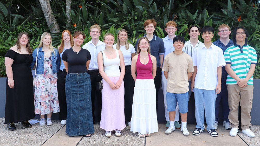 2024 graduates are standing and facing the camera.