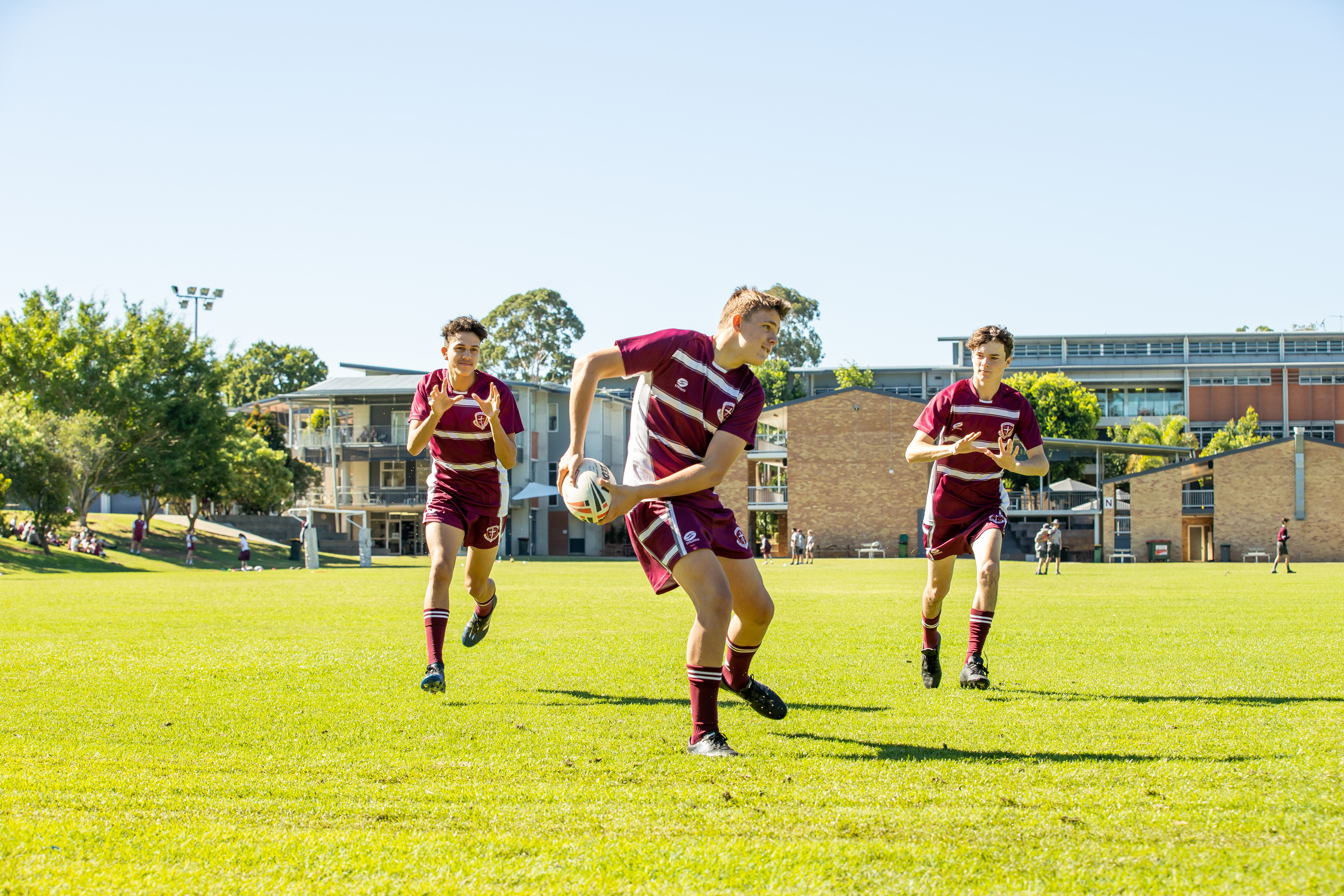 Three students playing rugby.