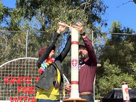 Two teachers light a candle.