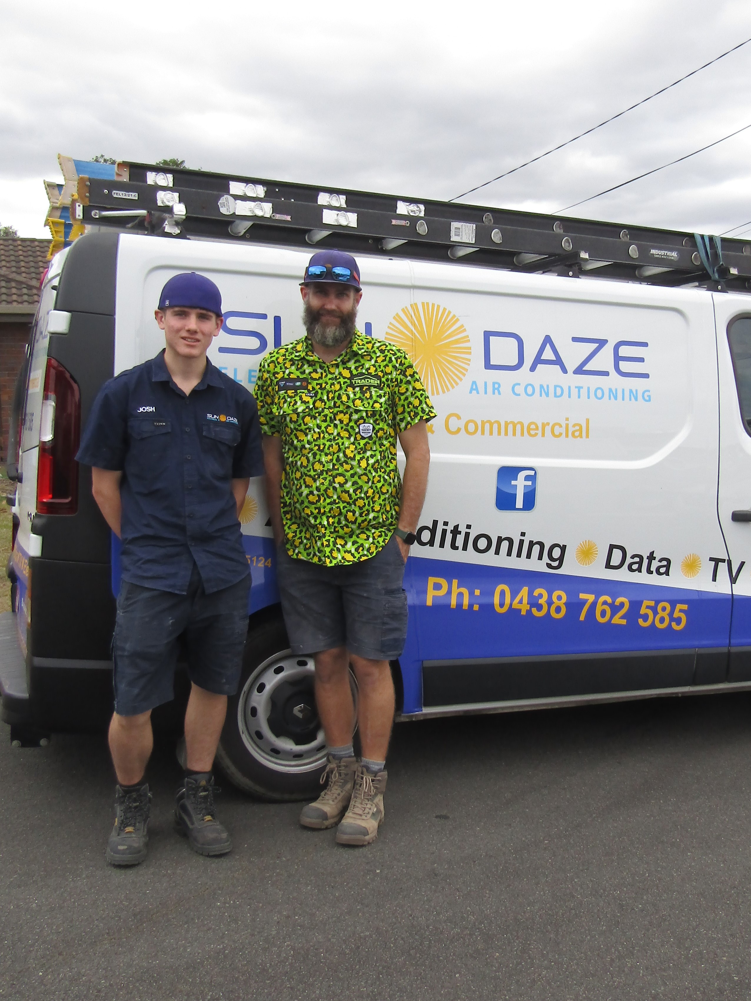 A student with mentor standing in front of air-conditioning service van.