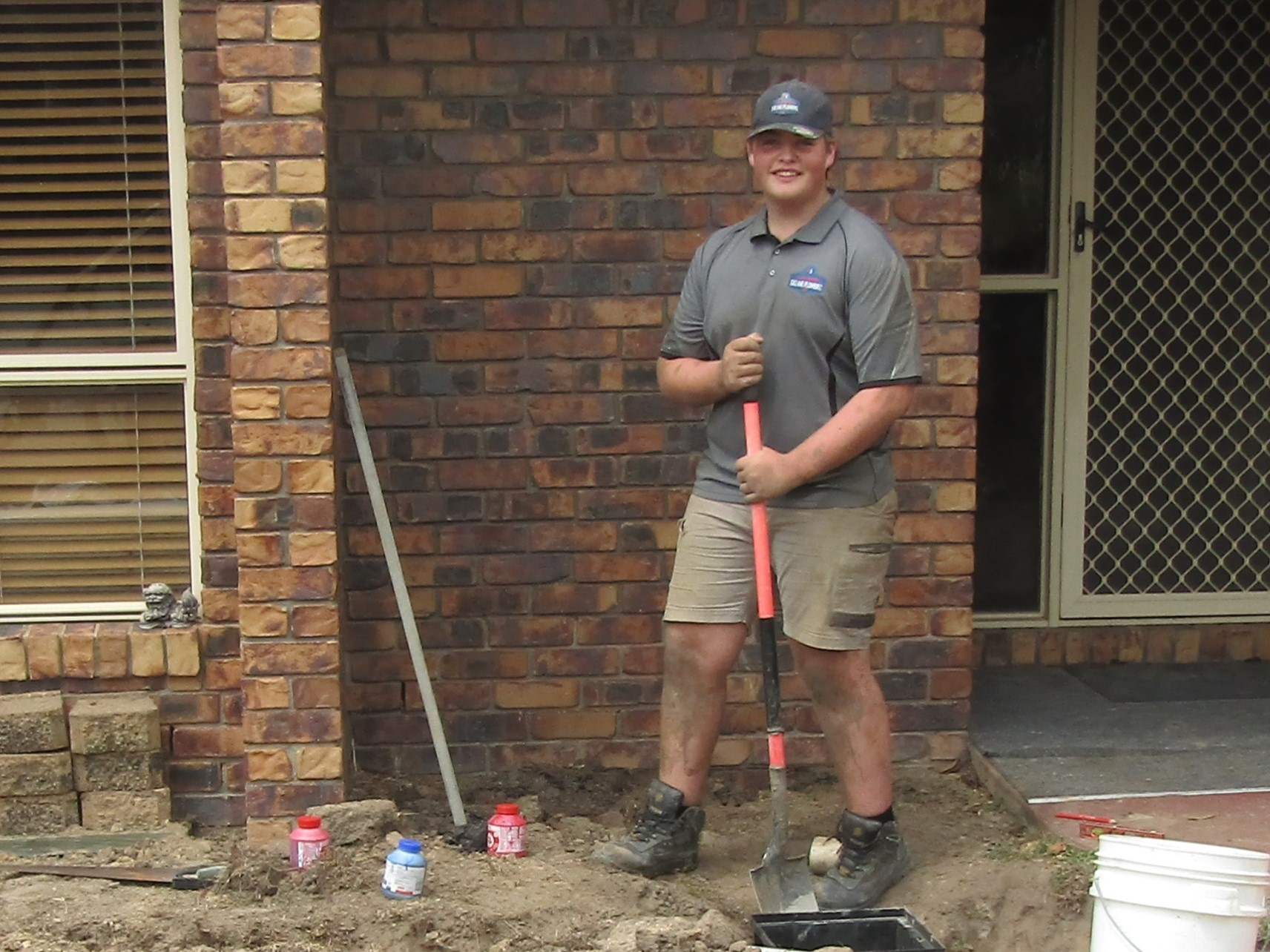 A student on a construction site with a shovel.