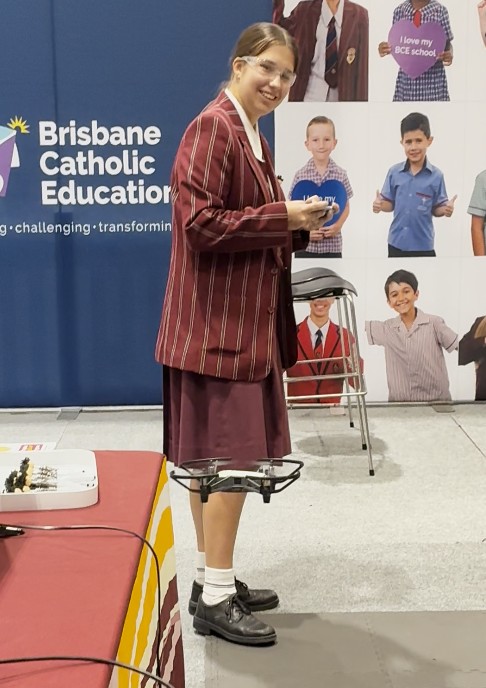 Student flying a drone at education fair.