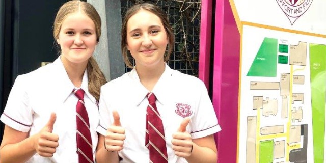 Two students giving the thumbs up.